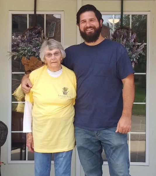A resident and a visitor standing together on the front porch of Lavender Fields