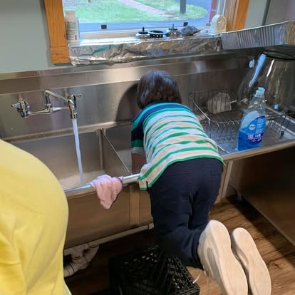 Traci scrubbing the commercial sink in the kitchen at Lavender Fields